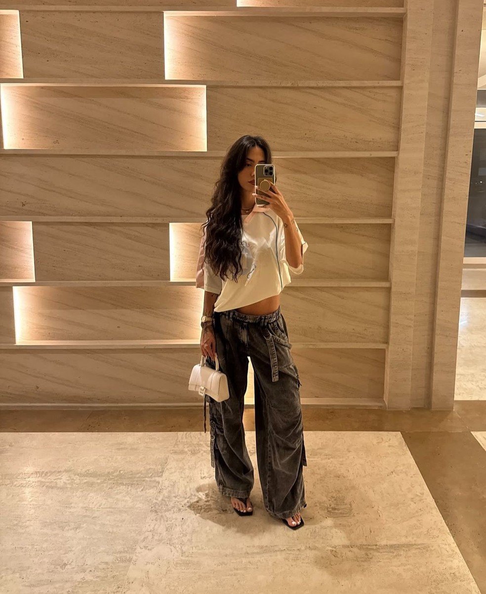 Clássico do streetwear, a influenciadora Gabi Brandt combinou sua calça cargo jeans com camiseta oversized. — Foto: Reprodução / Instagram @gabibrandt