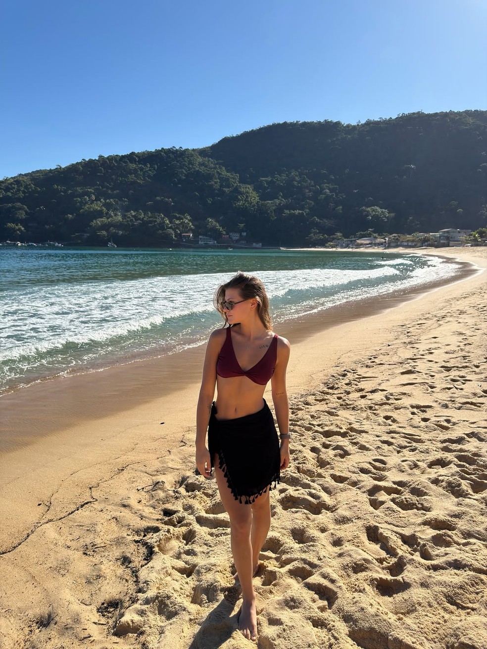 Nikki Meneghel caminha na areia — Foto: Reprodução/ Instagram @nikkimeneghel