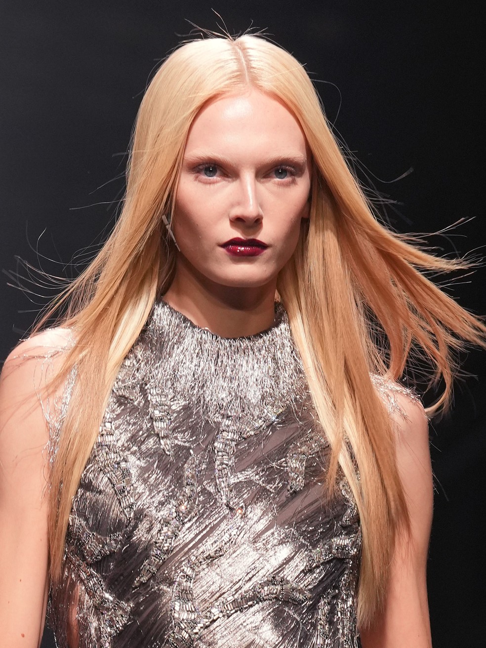 Cabelos chapados e lábios laqueados em bordô foi a beleza escolhida para o desfile Versace Outono-Inverno 2025 — Foto: Reprodução Getty Images
