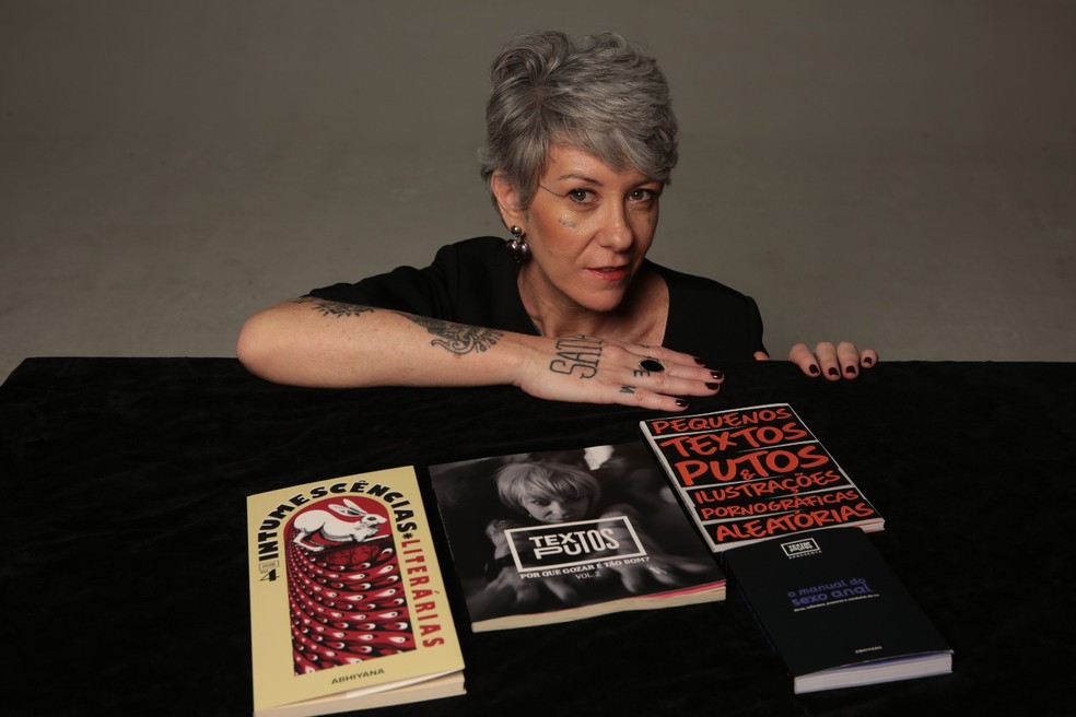 Abhiyana escritora, podcaster e ex-garota de programa posa com seus livros lançados — Foto: Reprodução/Acervo Pessoal/Gal Oppido