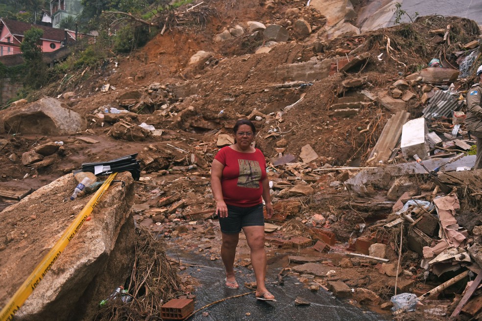 Mulher anda por escombros após deslizamentos em Petrópolis, no Rio de Janeiro - 19 de fevereiro de 2022 — Foto: Mauro Pimentel/AFP/Getty Images