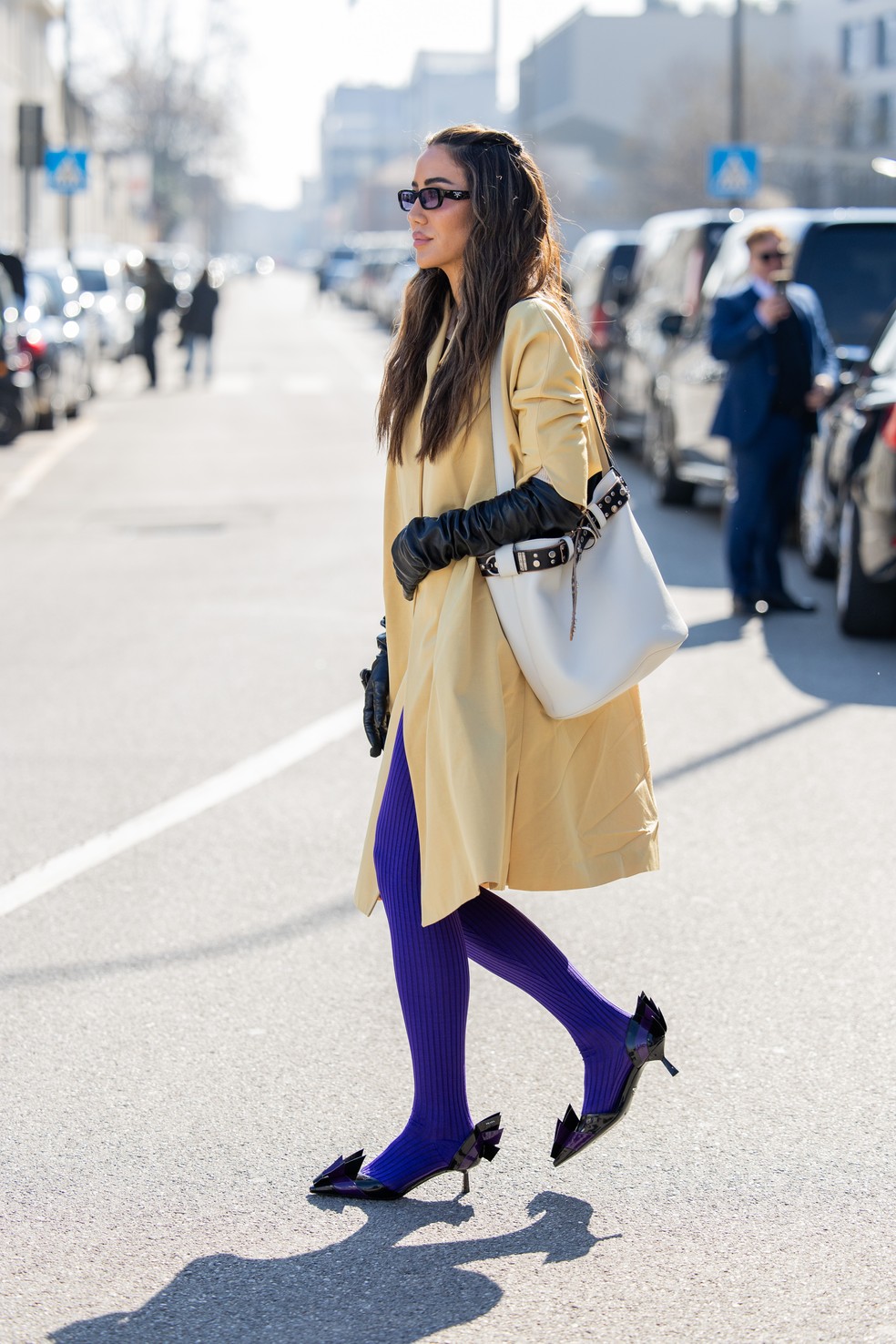 Tamara Kalinic usa casaco amarelo e meia calça roxa durante Semana de Moda de Milão — Foto: Getty Images
