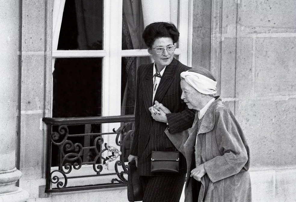 Simone de Beauvoir e Sylvie Le Bon chegam ao Palácio do Élysée, em Paris, para encontro com o presidente François Mitterrand, em 1985 (Foto: Getty Images) — Foto: Marie Claire