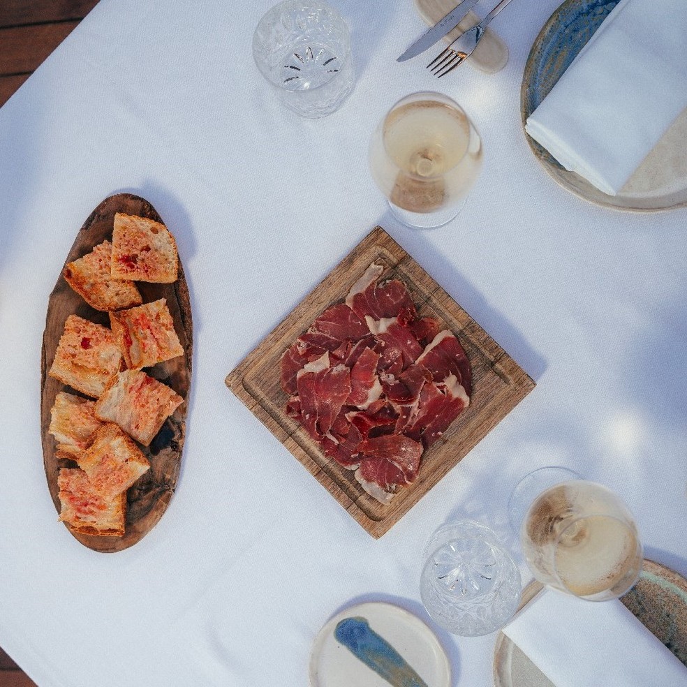 À esquerda, o famoso pan tomaca (pão, tomate ralado e azeite; muito simples, muito espanhol e muito gostoso) — Foto: Divulgação