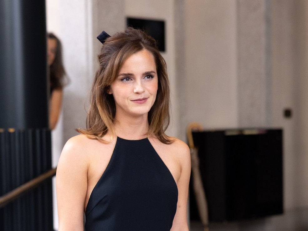 Emma Watson assisti ao desfile da Prada usando uma fita preta em penteado 60's — Foto: Getty Images