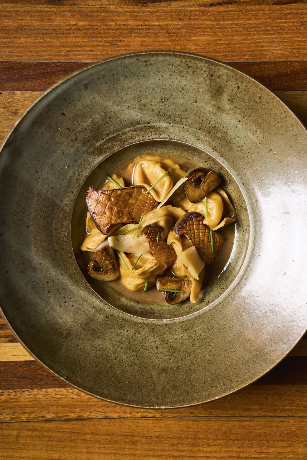 Sabores do Clandestina: tortelli recheado com queijo da Serra do Japi, caldo de cebola caramelizada e cogumelos salteados — Foto: Victor Affaro