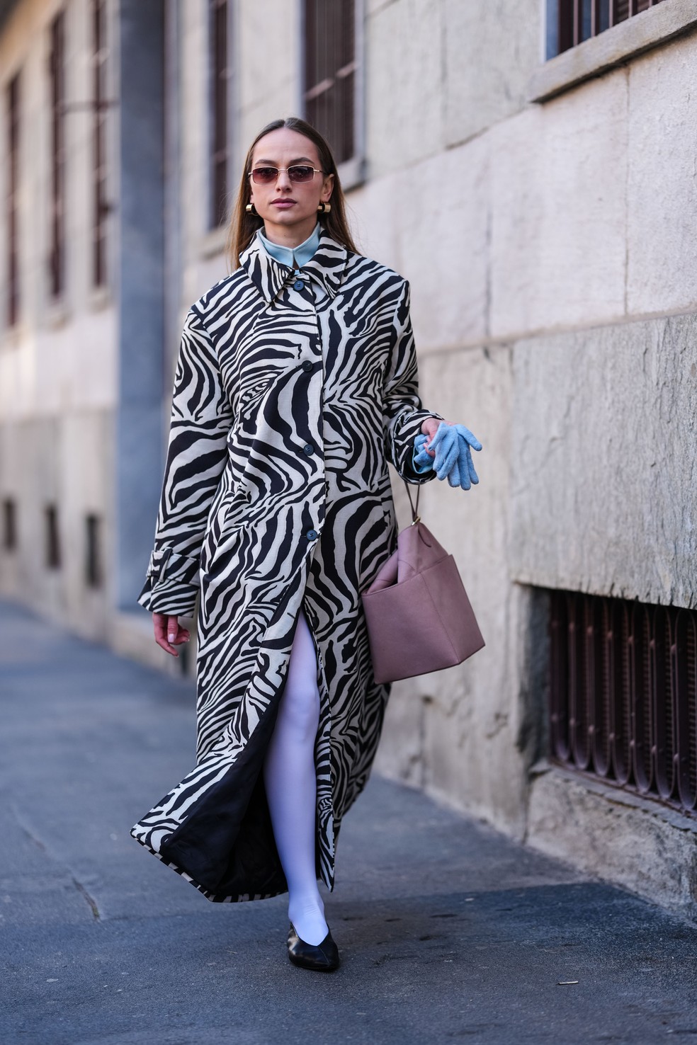 Convidada veste trench coat com estampa de zebra durante Semana de Moda de Milão — Foto: Getty Images